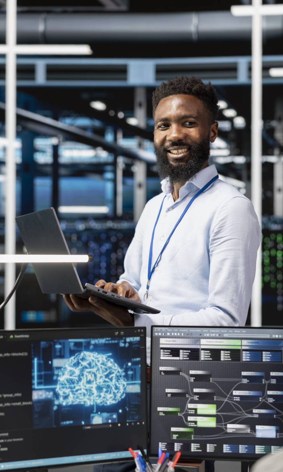Cheerful man in server hub facility using artificial intelligence to perform demanding computing tasks. Jolly admin in data center uses AI technology for machine learning workloads